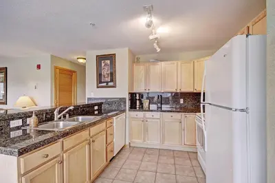 a kitchen with wooden cabinets and a white refrigerator at 522 Watch Hill Condo in Silverthorne
