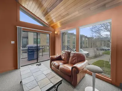 a living room with a leather chair and large windows at A308 Lake Cliffe Condo in Dillon