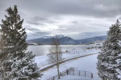 a snowy field with trees and a body of water at A308 Lake Cliffe Condo in Dillon