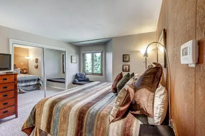 a bedroom with a large bed and a television at 1088 Wild Irishman Condo in Keystone