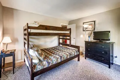 a bedroom with a bunk bed and a television at 1088 Wild Irishman Condo in Keystone