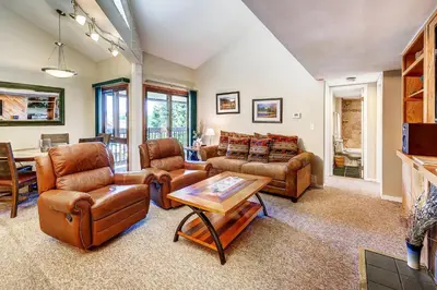 a living room with leather furniture and a table at 1088 Wild Irishman Condo in Keystone