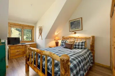 a bedroom with a wooden bed and a television at 2674 Tenderfoot Lodge Condo in Keystone