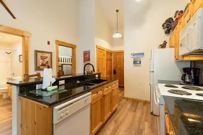 a kitchen with wooden cabinets and a white refrigerator at 2674 Tenderfoot Lodge Condo in Keystone
