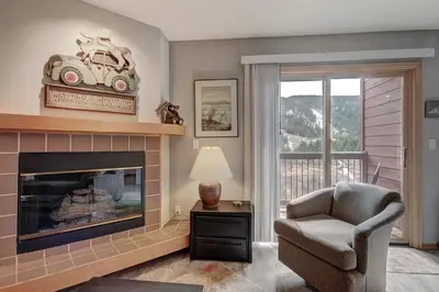 a living room with a fireplace and a chair at C213 Cinnamon Ridge Condo in Keystone