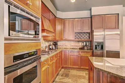 a kitchen with wooden cabinets and stainless steel appliances at 3044 Lone Eagle Condo in Keystone