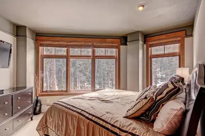 a bedroom with a bed and two windows at 3044 Lone Eagle Condo in Keystone
