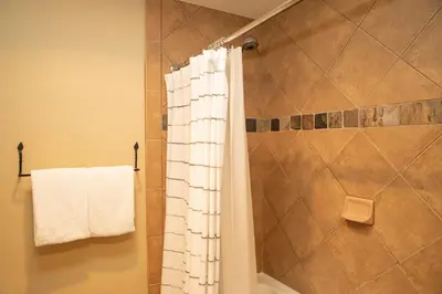 a bathroom with a shower with a white shower curtain at 6532 Settlers Creek Condo in Keystone