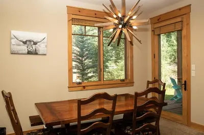 a dining room with a wooden table and a chandelier at 6532 Settlers Creek Condo in Keystone