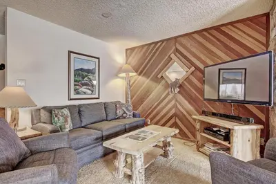 a living room with a couch and a tv at Cri221 Cinnamon Ridge Condo in Keystone