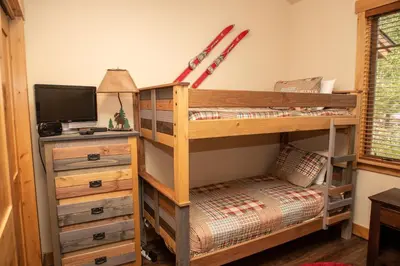 a room with a bunk bed and a desk with a television at 6506 Settlers Creek Condo in Keystone