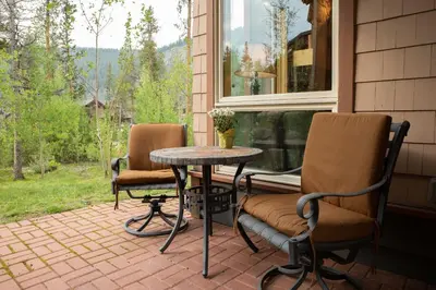 a patio with two chairs and a table and a window at 6506 Settlers Creek Condo in Keystone