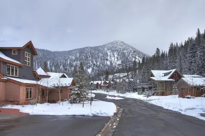 a snow covered street in a town with a mountain at 6506 Settlers Creek Condo in Keystone
