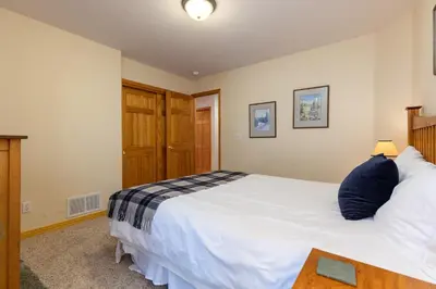 a bedroom with a large white bed and a table at 130 Meisel Drive Townhouse in Keystone