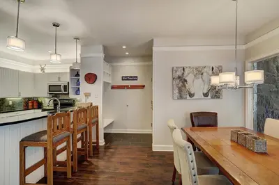 a kitchen and dining room with a wooden table and chairs at 2721 Chateaux DMont Condo in Keystone