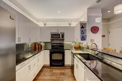 a kitchen with white cabinets and black appliances at 2721 Chateaux DMont Condo in Keystone