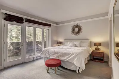 a bedroom with a white bed and a red stool at 2721 Chateaux DMont Condo in Keystone