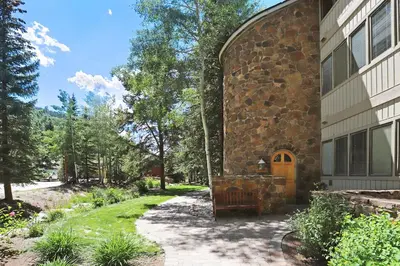 a stone house with a bench next to a building at 2721 Chateaux DMont Condo in Keystone