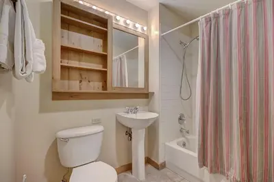 a bathroom with a toilet and a sink and a tub at 8493 Dakota Lodge Condo in Keystone