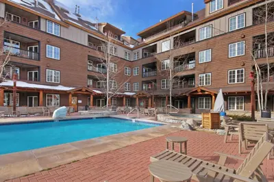 a swimming pool in front of a large building at 8493 Dakota Lodge Condo in Keystone