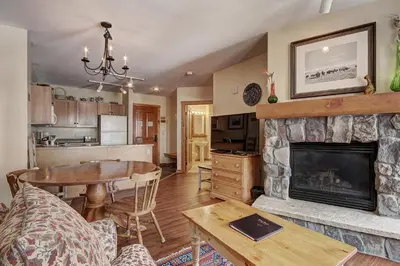 a living room with a fireplace and a table at 8493 Dakota Lodge Condo in Keystone
