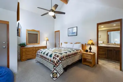 a bedroom with a bed and a bathroom with a sink at 1610 Quicksilver Condo in Keystone