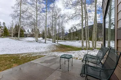 a porch with two chairs and a table in the snow at 1610 Quicksilver Condo in Keystone