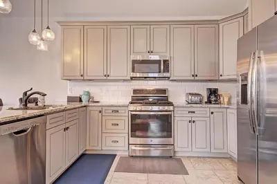 a kitchen with white cabinets and stainless steel appliances at 78 Alders Townhouse with Heated Garage in Keystone