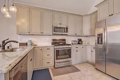 a kitchen with white cabinets and stainless steel appliances at 78 Alders Townhouse with Heated Garage in Keystone