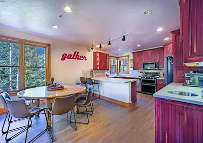 a kitchen with red cabinets and a table and chairs at 202 Mill Creek Condo in Keystone