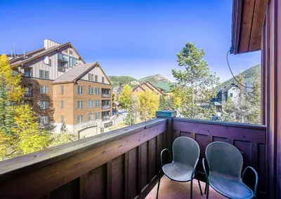 two chairs sitting on a balcony with a view at 202 Mill Creek Condo in Keystone