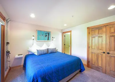 a bedroom with a blue bed and a wooden door at 202 Mill Creek Condo in Keystone