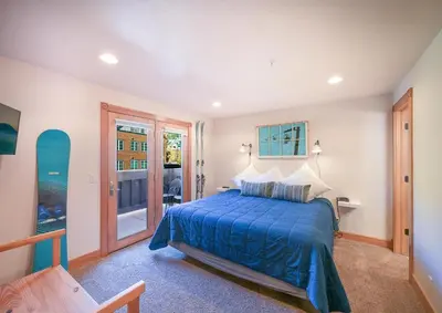 a bedroom with a bed with a blue bedspread at 202 Mill Creek Condo in Keystone