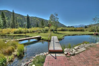 a wooden bridge over a pond in a field at 202 Mill Creek Condo in Keystone