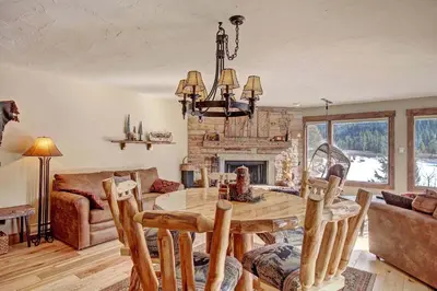 a dining room with a table and a fireplace at 1710 the Willows Condo in Snake River Health Services Incorporated Heliport