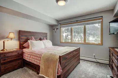 a bedroom with a bed and a window and a television at C212 Cinnamon Ridge Condo in Keystone