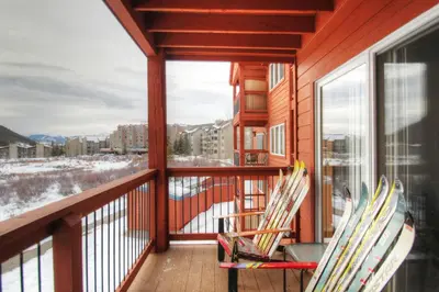 two chairs on a balcony with a view of the snow at C212 Cinnamon Ridge Condo in Keystone
