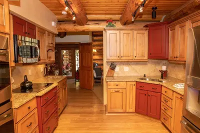a large kitchen with red cabinets and wooden floors at 13 Bear Tree Court Condo in Keystone