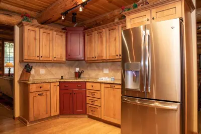 a kitchen with wooden cabinets and a stainless steel refrigerator at 13 Bear Tree Court Condo in Keystone