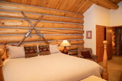 a bedroom with a bed and a wooden wall at 13 Bear Tree Court Condo in Keystone