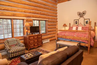 a log cabin bedroom with a bed and a tv at 13 Bear Tree Court Condo in Keystone