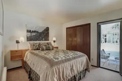 a bedroom with a bed and a window with a chair at 1125 Flying Dutchman Condo in Keystone