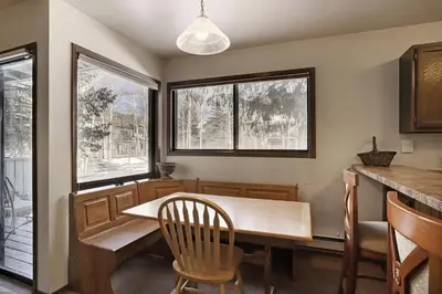 a dining room with a table and two windows at 1125 Flying Dutchman Condo in Keystone