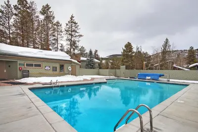 a swimming pool with blue water in a yard at 1125 Flying Dutchman Condo in Keystone