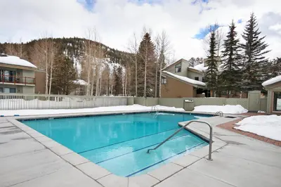 a swimming pool in a yard with snow on the ground at 1125 Flying Dutchman Condo in Keystone