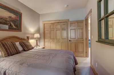 a bedroom with a bed and a wooden door at 8757 Trappers Crossing Condo in Keystone