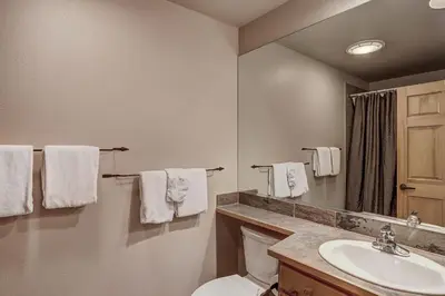 a bathroom with a toilet and a sink and a mirror at 8757 Trappers Crossing Condo in Keystone
