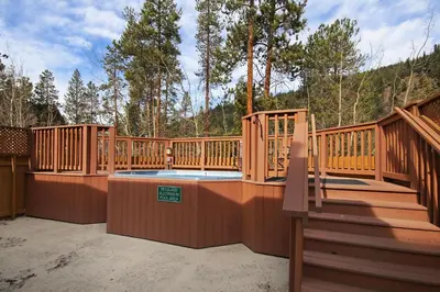 a large deck with a hot tub and stairs at 8757 Trappers Crossing Condo in Keystone