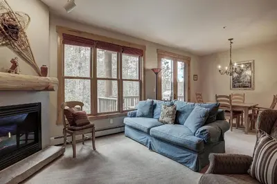 a living room with a blue couch and a fireplace at 8757 Trappers Crossing Condo in Keystone