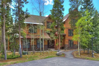 a log house with a driveway in front of it at 8757 Trappers Crossing Condo in Keystone